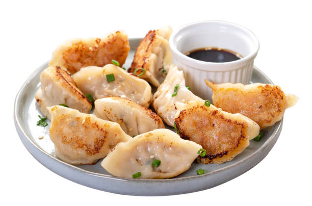 istock Pan-fried gyoza dumpling jiaozi in a plate isolated on white background. 1421314097