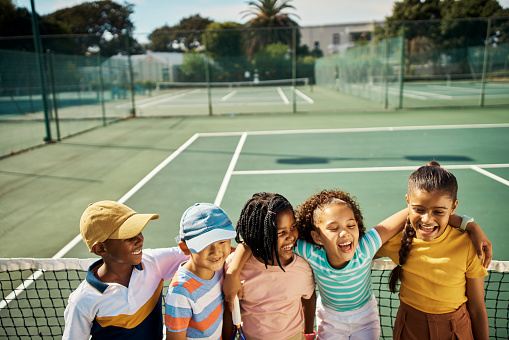 Diversity, friends and fitness, kids on a tennis court in the sun. Youth, growth and school, a boy and girl sports team learning for development and exercise. Smile, summer and play, fun for children