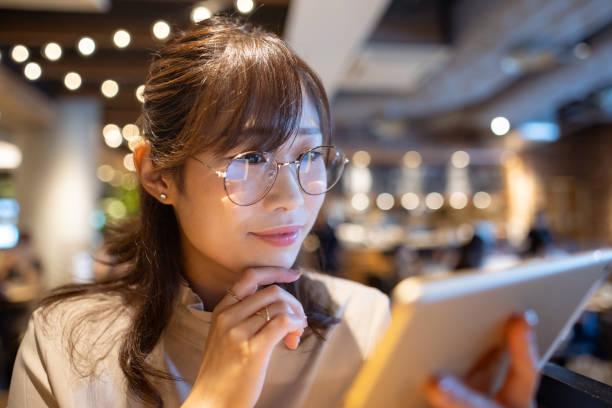 istock Female freelance worker reading message on digital tablet in cafe 1421318751