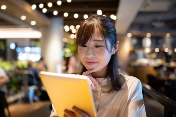 istock Female freelance worker reading message on digital tablet in cafe 1421319126