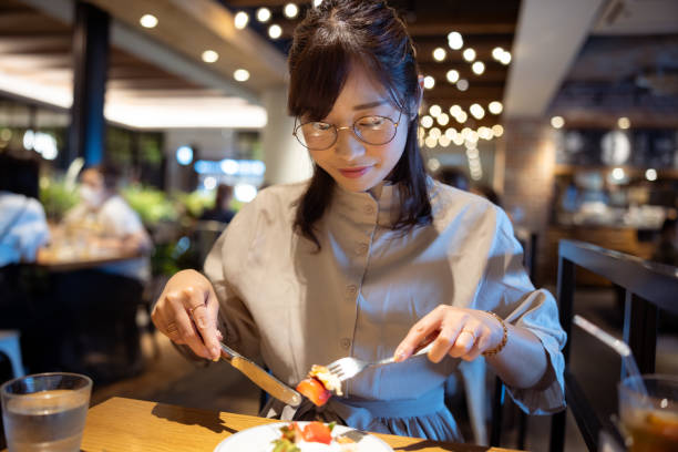 istock Female freelance worker eating dessert in cafe 1421319375