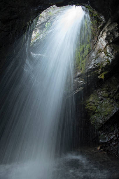istock Beautiful waterfall flowing into underground chamber of a cave 1421319547