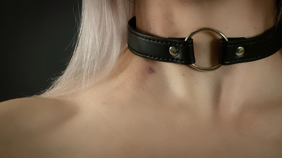 Choker. Necklace work around the neck. Blonde with a choker around her neck. BDSM accessories. Erotic Photo Close Up