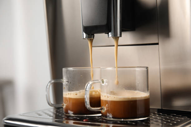 istock Espresso machine pouring coffee into glass cups against blurred background, closeup 1421320136