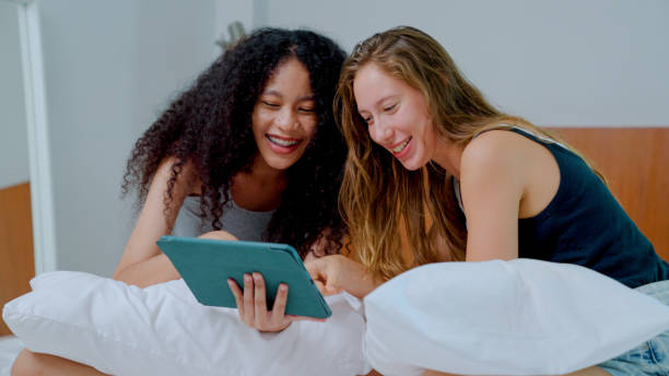 istock Young Lesbian Couple Using Browsing Social Media while Staying at a Luxury Hotel. 1421320435
