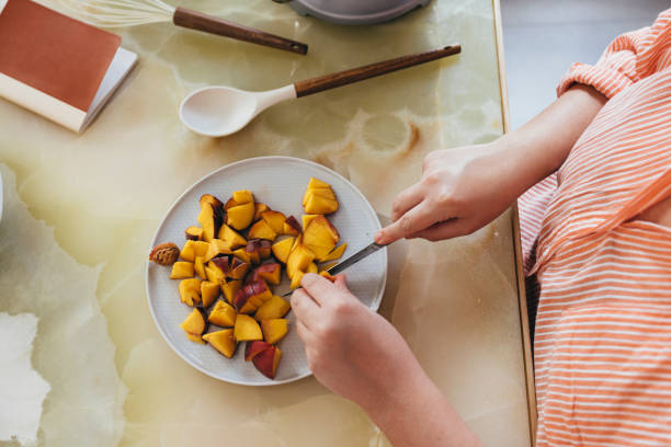 istock Anonymous Woman Cutting Fruit 1421320715
