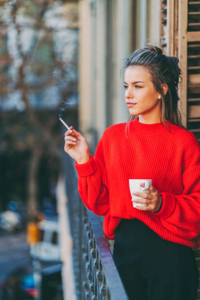 istock Relaxed woman smoking at the terrace 1421321579