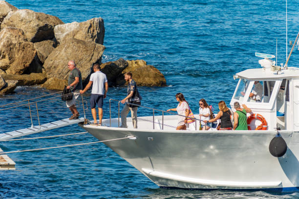 Group of Tourists Get Off a Small Ferry - Tellaro Liguria Italy stock photo