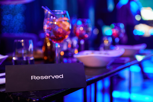 Reserved table in night club against the background of multi-colored spotlights