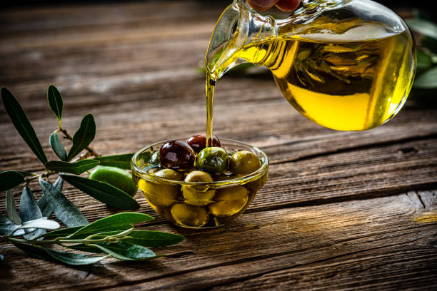 pouring extra virgin olive oil on organic olives - virgin olive oil imagens e fotografias de stock