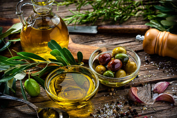 olives and extra virgin olive oil on rustic table - virgin olive oil imagens e fotografias de stock