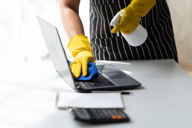 istock Asian young man cleaning his computer table with rag and spray cleaner. 1421327730