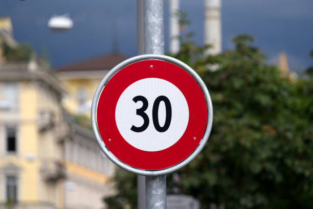 limite de vitesse des panneaux de signalisation 30 kilomètres à l’heure dans la ville de lugano par une journée d’été nuageuse. - kilometers per hour photos et images de collection