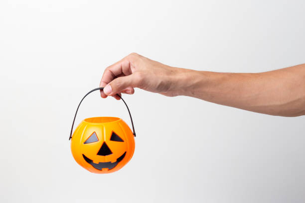 istock hand holding Halloween bucket isolated on white background 1421329615