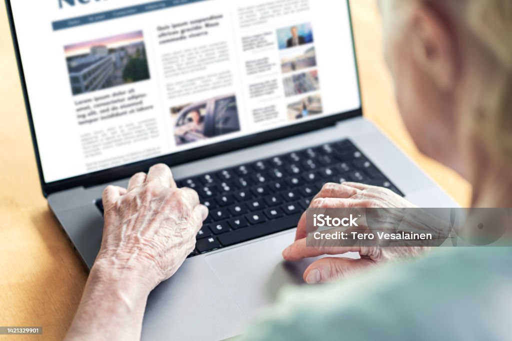 News website in laptop of an old woman. Elder senior and grandma reading digital newspaper with computer. Online magazine or web article in screen. News website in laptop of an old woman. Elder senior and grandma reading digital newspaper with computer. Online magazine or web article in screen. Daily information publication site by the press. Internet Stock Photo