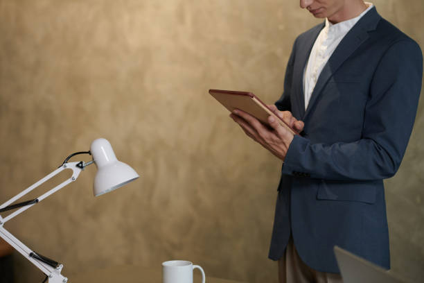 istock Businessman Reading Report on Tablet 1421330076