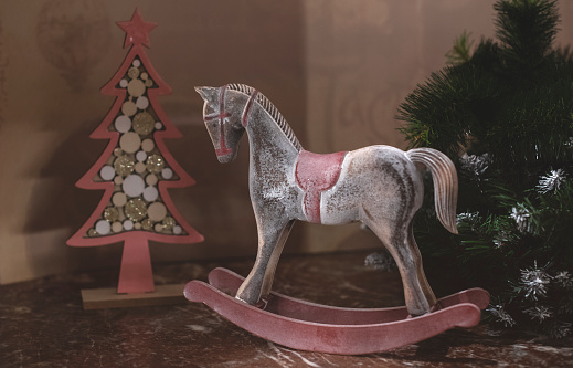 Christmas composition of a wooden horse and a Christmas tree in a rustic style.
