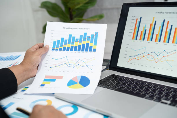 istock Asian accountant working and analyzing financial reports project accounting with chart graph in modern office, finance and business concept. 1421343483