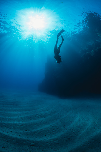a girl dives in apnea in a Mediterranean seabed in Calabria (Italy)