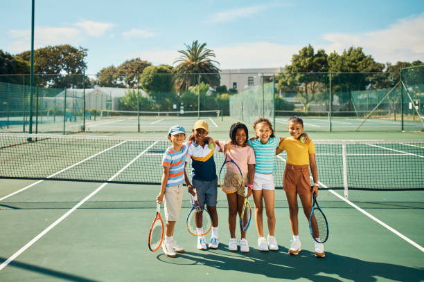 equipo de la escuela de tenis para niños jugando partido, competencia y juego divertido en la soleada cancha al aire libre del club deportivo. retratar a amigos jóvenes, niños felices y jóvenes de diversidad con un estilo de vida activo, saludable y en - tennis child childhood sport fotografías e imágenes de stock