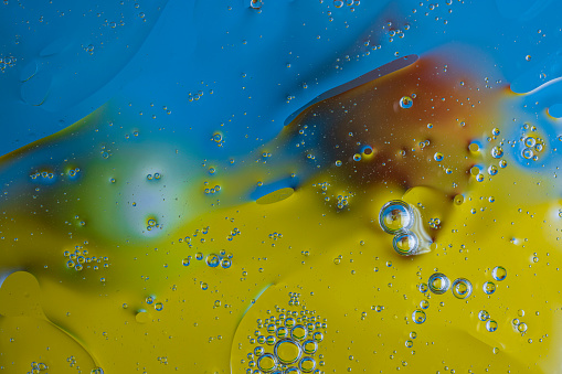 Close up view of beautiful water with yellow blue and orange colorful abstract design texture.