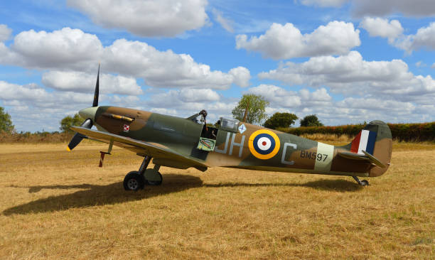 vintage spitfire bm597 (g-mkvb) mk.vb statyczny na lądowisku z błękitnym niebem i chmurami. - spitfire airplane world war ii airshow zdjęcia i obrazy z banku zdjęć