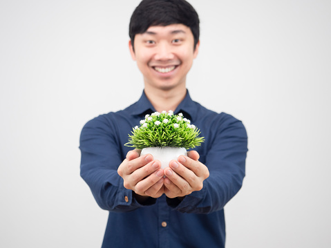 Asian man holding flowerpot in hand with smile face and cheerful,Man give vase in his hand white background