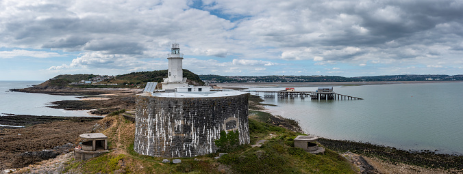 aerial view of the Mumbles headland with the historic lighthouse and piers in Swansea Bay