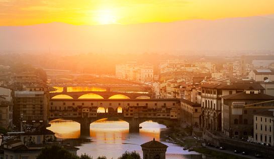 calm Evening over the empty Florence. Arno river and famous Ponte Vecchio enlighten by the warm sunlight. Italy.