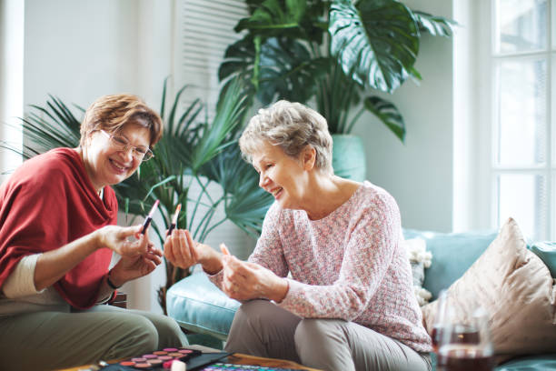 istock Two active senior women putting on make up together 1421352016