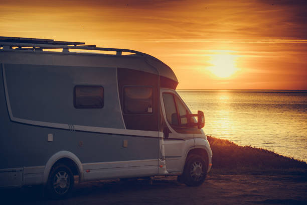 istock Camper vehicle on beach at sunrise 1421353085