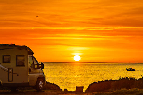 istock Camper vehicle on beach at sunrise 1421353254