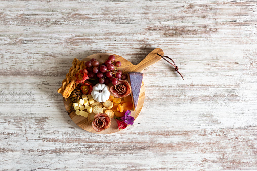 Top view of a charcuterie board on a white rustic wood background