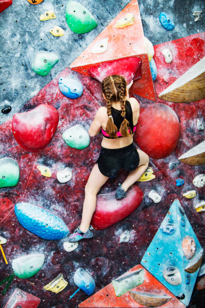 istock Little girl training on rock-climbing wall 1421356305