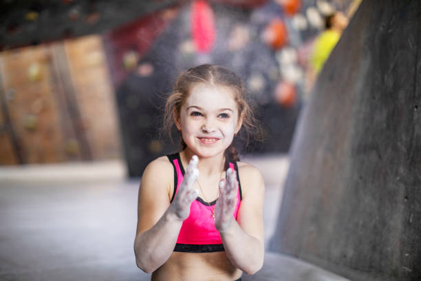 Little girl training on rock-climbing wall