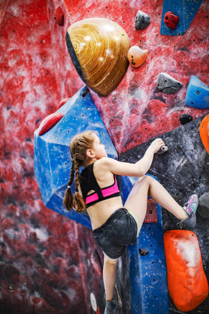 istock Little girl training on rock-climbing wall 1421356456