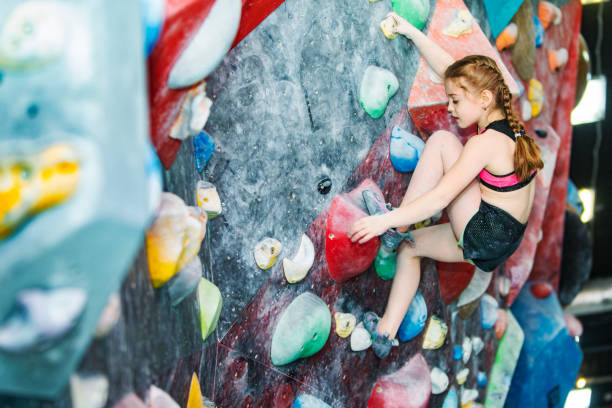 istock Little girl training on rock-climbing wall 1421356479