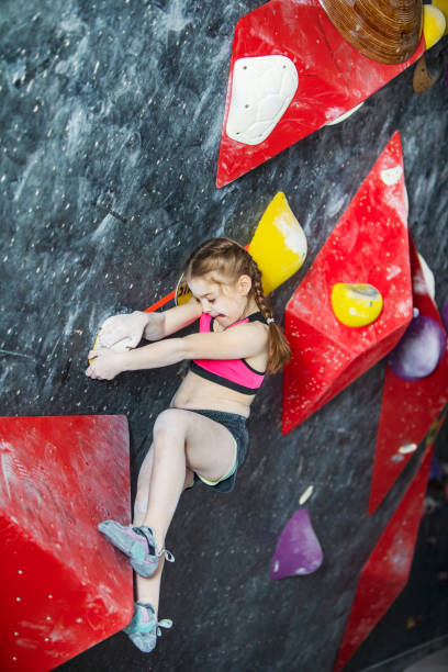 istock Little girl training on rock-climbing wall 1421356544
