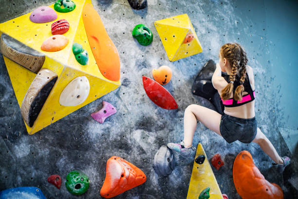 istock Little girl training on rock-climbing wall 1421356596
