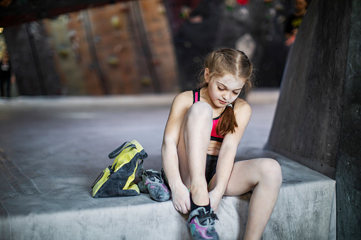 Little girl training on rock-climbing wall