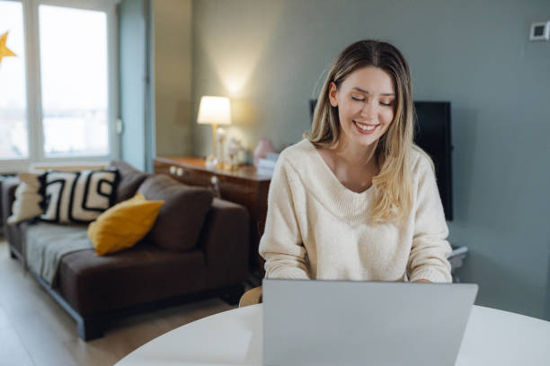 istock Young woman using laptop at home 1421361625