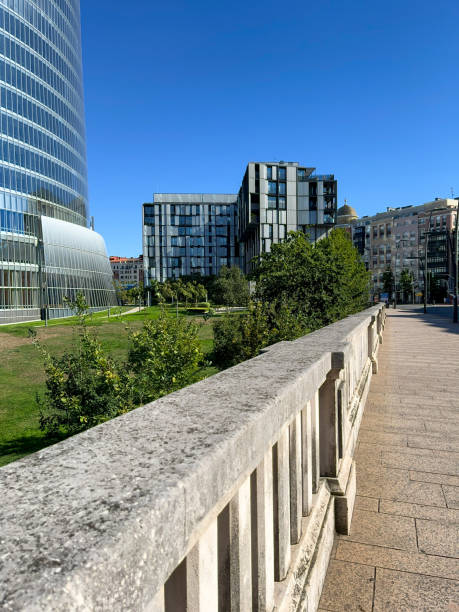 istock basque glass industry tower in bilbao's tree-lined park with modern building 1421365381