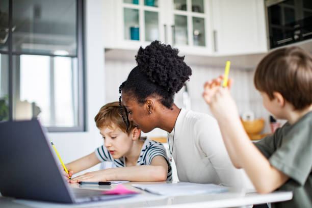 istock Two Elementary School Boys Having Lessons At Home With African Private Teacher 1421369592