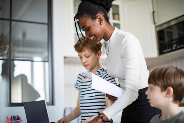 istock Two Elementary School Boys Having Lessons At Home With African Private Teacher 1421369921