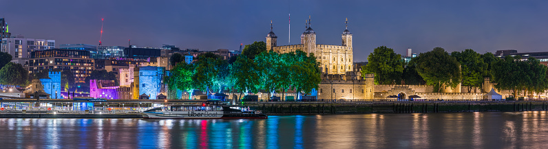 The historic battlements of the Tower of London illuminated at night along the River Thames in the heart of the UK’s capital city.