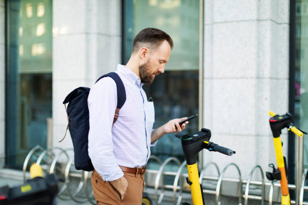 istock Young adult man using electro scooter at the city 1421373598
