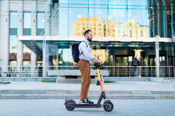 istock Young adult man using electro scooter at the city 1421373650