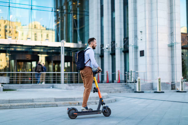 istock Young adult man using electro scooter at the city 1421373652