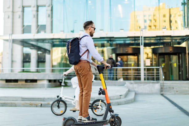 istock Young adult man using electro scooter at the city 1421373659