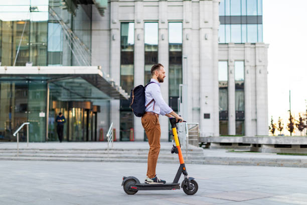 istock Young adult man using electro scooter at the city 1421373662
